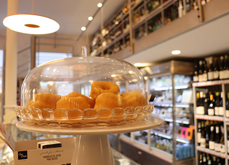 Una expositor elevado redondo, con tapa de cristal dónde se pueden ver productos dulces