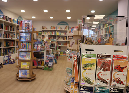 Vista del interior de la librería, dónde se pueden ver varias estanterías y expositores. En primer plano se ve un expositor de puzles 3D de animales