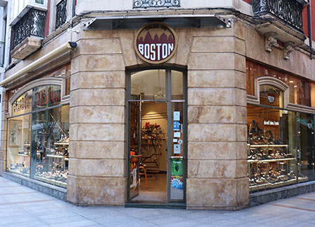 Vista del exterior de la zapatería, dónde podemos ver la puerta de entrada situada en una esquina y dos grandes escaparates que dan a ambas calles